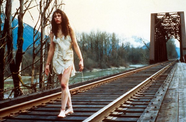 girl walks along railroad